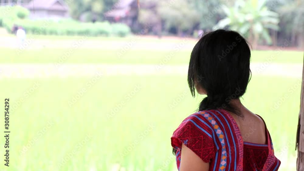 A girl in traditional dress Karen ethnicity sitting in a paddy field A girl in traditional dress Karen ethnicity sitting in a paddy field