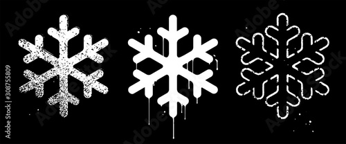 Vector set of abstract snowflakes. Grunge urban style. White imprints on a black background. Distressed sponged texture, paint streaks and splatter. Rough symbols of harsh winter and dangerous frost