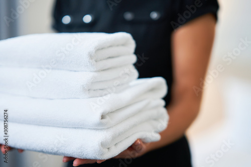 Maid with fresh towels in hotel room