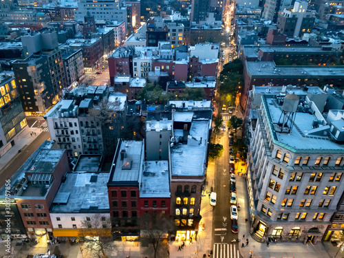 Overhead view of the busy streets of Nolita and SoHo neighborhoods with colorful night lights shining at dusk in Manhattan, New York City