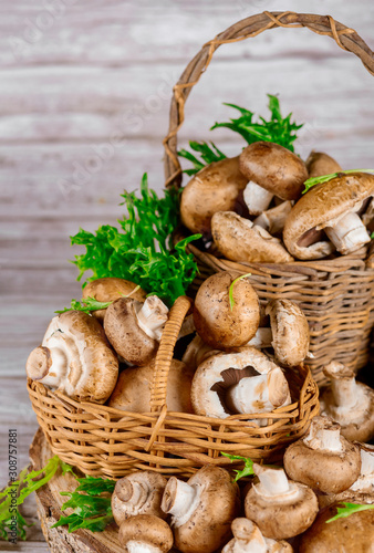 Brown mushrooms in wooden wicker baskets on wooden background.