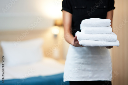 Maid with fresh towels in hotel room photo