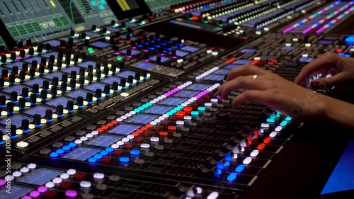Close-up of a mixing console, the hand adjusts the faders Professional recording studio.