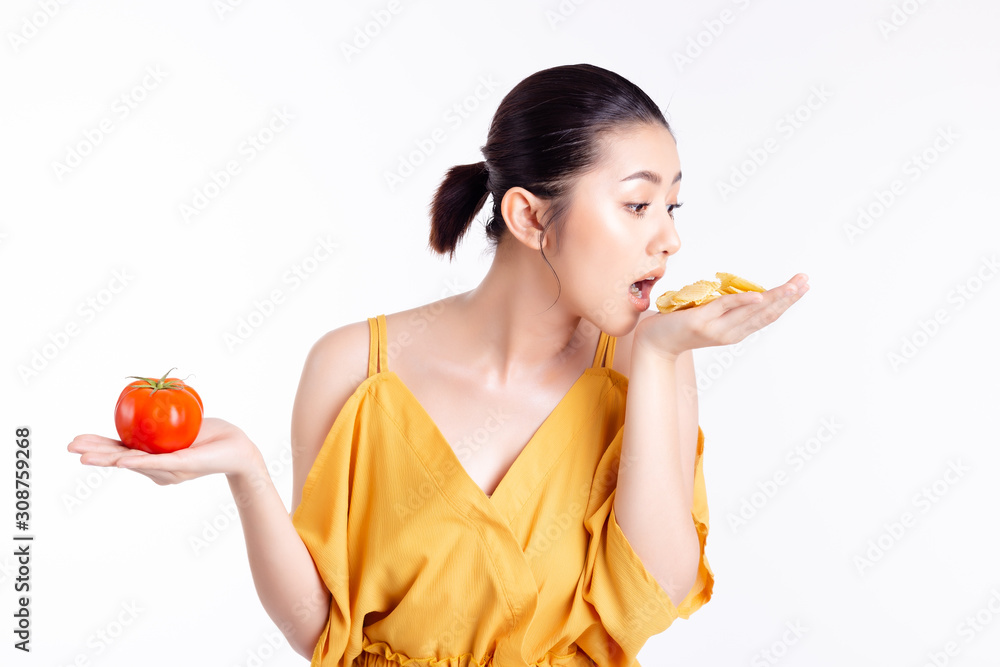 Asian woman want to diet but beautiful young girl can’t patient to eat snack or potato chip. Pretty woman holding tomato or vegetable and tomato chip on hands, interest snack more than healthy food Asian woman want to diet but beautiful young girl can’t patient to eat snack or potato chip. Pretty woman holding tomato or vegetable and tomato chip on hands, interest snack more than healthy food