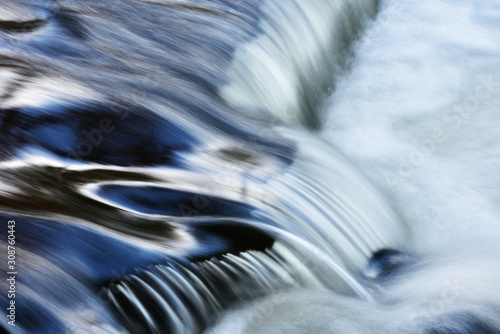 Bond Falls cascade captured with motion blur and illuminated by reflected color from blue sky overhead, Michigan's Upper Peninsula, USA