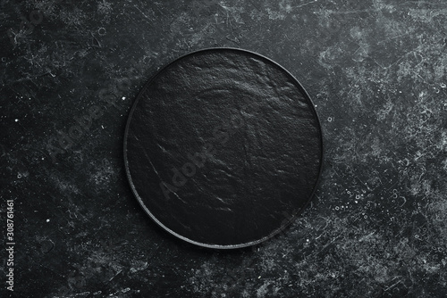 Фотография Black plate on black stone background
