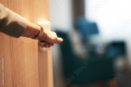 Half-open door of a hotel bedroom with hand photo