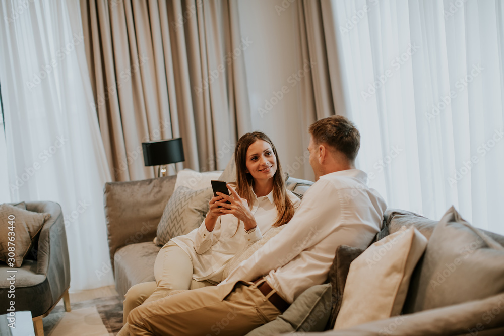 Young couple relaxing on couch in luxury living room Young couple relaxing on couch in luxury living room
