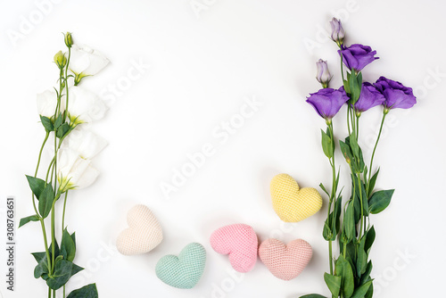 Creative layout with eustoma flowers and small hearts on white background, flat lay, top view. Love concept