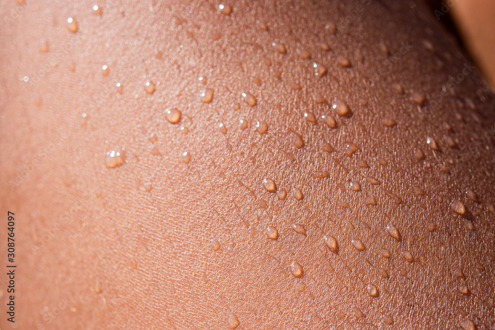 Fototapeta premium Water drops on a human leg in close up