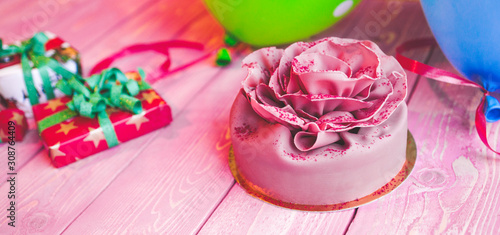 Fototapeta Naklejka Na Ścianę i Meble -  Pink cake Birthday, Valentines Day, presents and colorful balloons on a light pink wooden board. Concept celebration.