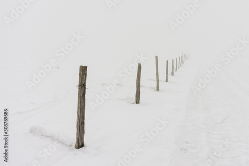 an old wooden fence in the snow