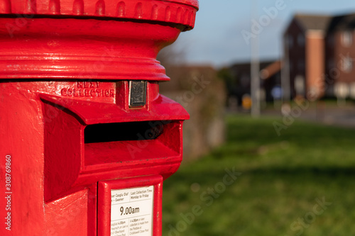 A classic vintage red mailbox for posting letters in a Street in Wales, United Kingdom photo