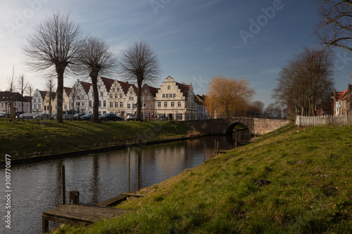 picture postcard view to a picturesque canal and the historic gable houses in Duch architecture in Friedrichstadt