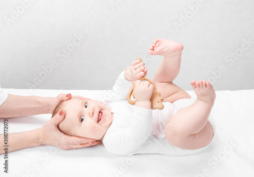 Foto Little baby receiving osteopathic treatment of head and neck