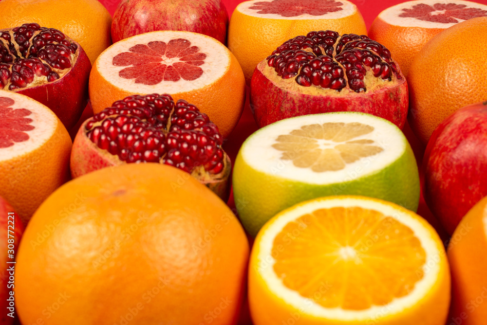 Grapefruit, orange, pomegranate, citrus sweetie on red background. Grapefruit, orange, pomegranate, citrus sweetie on red background.