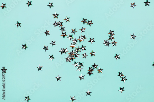 Silver flying stars on blue holiday background. Festive backdrop for your projects.