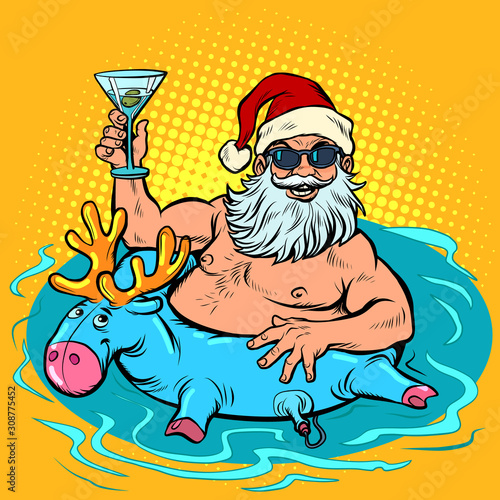 New year party. Santa clays at the resort in the pool with an inflatable deer and a cocktail