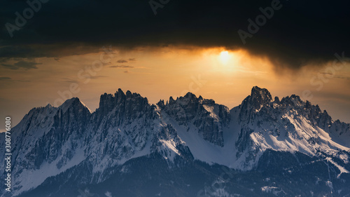 Snowy rocky mountain with a beautiful cloudy dramatic sunsetspace fort text © Davide Marconcini