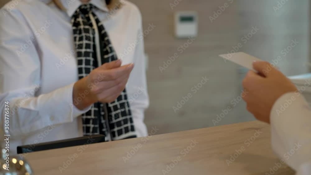 Receptionist assisting hotel guest at desk Receptionist assisting hotel guest at desk