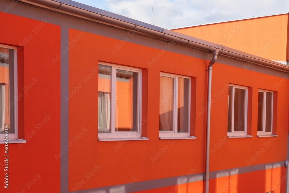 Orange Fassade mit Fenstern
