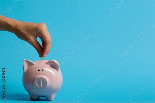 Slika na platnu woman hand putting money coin into piggy for saving money wealth and financial c
