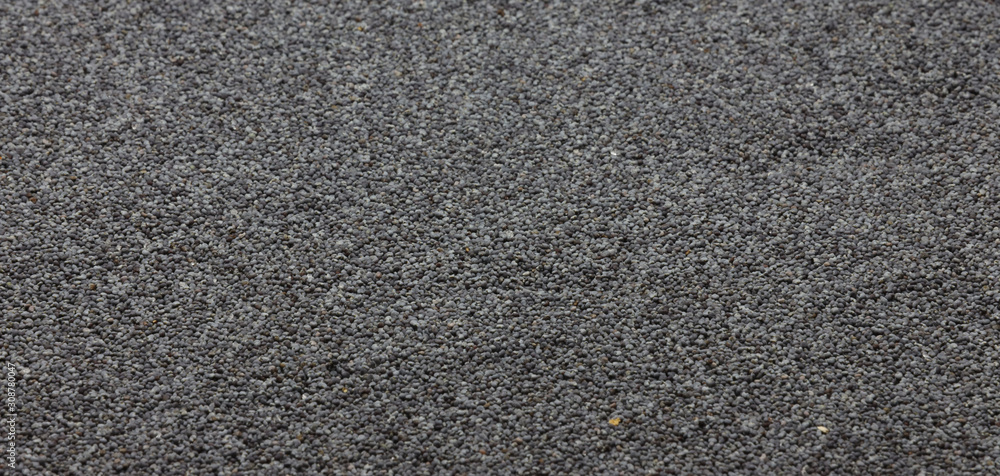 Raw blue poppy seeds scattered on a flat surface. Background. Tор view . Raw blue poppy seeds scattered on a flat surface. Background. Tор view .
