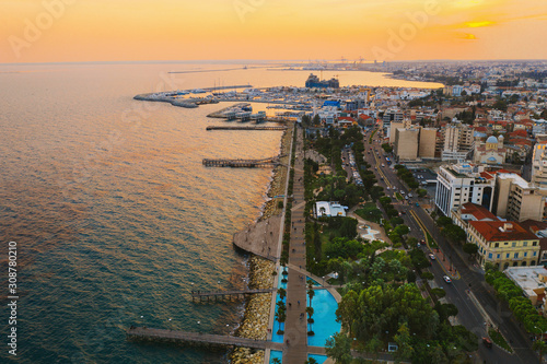 Limassol promenade at sunset, Cyprus. Aerial panoramic view of evening Limassol with Molos Park from above, drone photo. Mediterranean evening landscape, beautiful Cyprus resort for vacation.