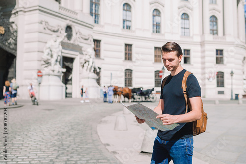 Canvas Print Man tourist with a city map and backpack in Europe street