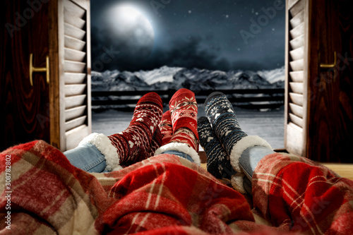 Woman legs with window sill and free space for your decoration.Christmas time and dark december night 