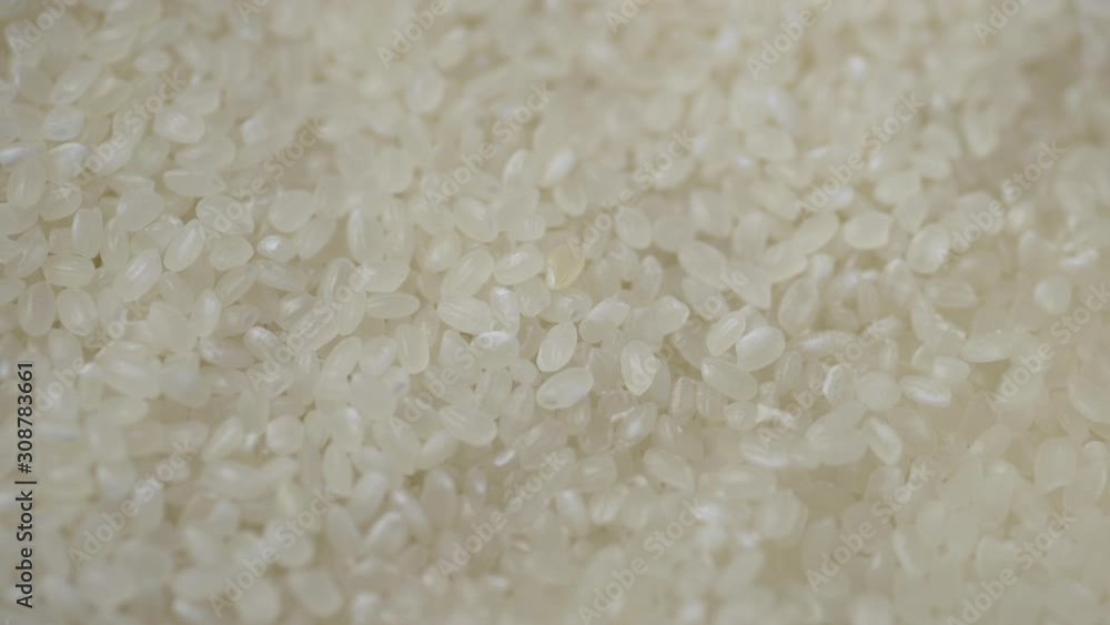 Making Japanese sushi rice, flooding raw dry rice grain with water close up. Making Japanese sushi rice, flooding raw dry rice grain with water close up.