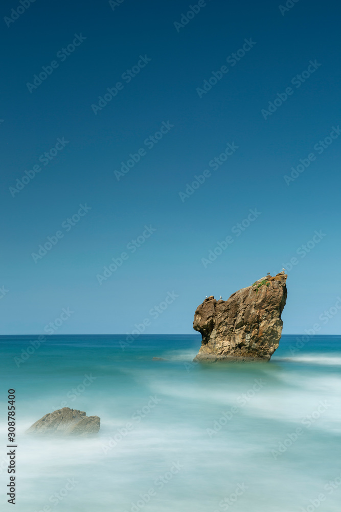 Marea alta en la playa de Aguilar con el agua de mar cubriendo por completo la arena de la playa. Muros de Nalón, costa de Asturias, España