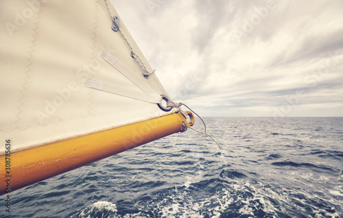 Fototapeta Naklejka Na Ścianę i Meble -  Close up picture of old schooner sail tip, selective focus, color toning applied.
