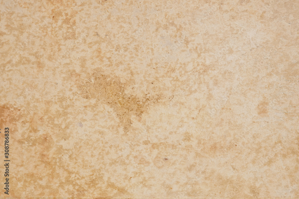 The surface is beige. Cardboard cover of an old book. View from above. Large brown spots, scuffs, stratification of the material. Light background or wallpaper. Reduced contrast. Macro The surface is beige. Cardboard cover of an old book. View from above. Large brown spots, scuffs, stratification of the material. Light background or wallpaper. Reduced contrast. Macro