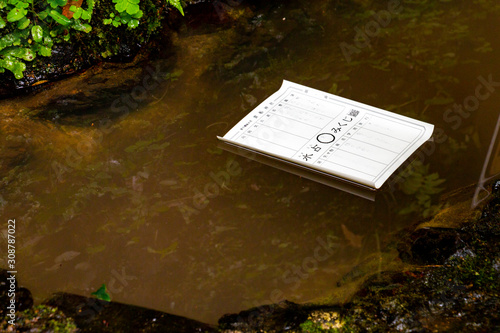 A fortune slip at Kifune Shrine. The paper reads 