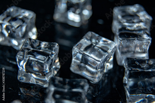 Ice cubes on black wet table. Selective focus / close up