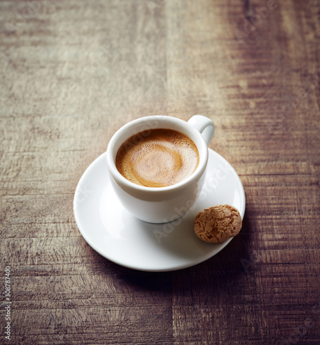 Cup of coffee with Amaretti Cookie on rustic wooden background.