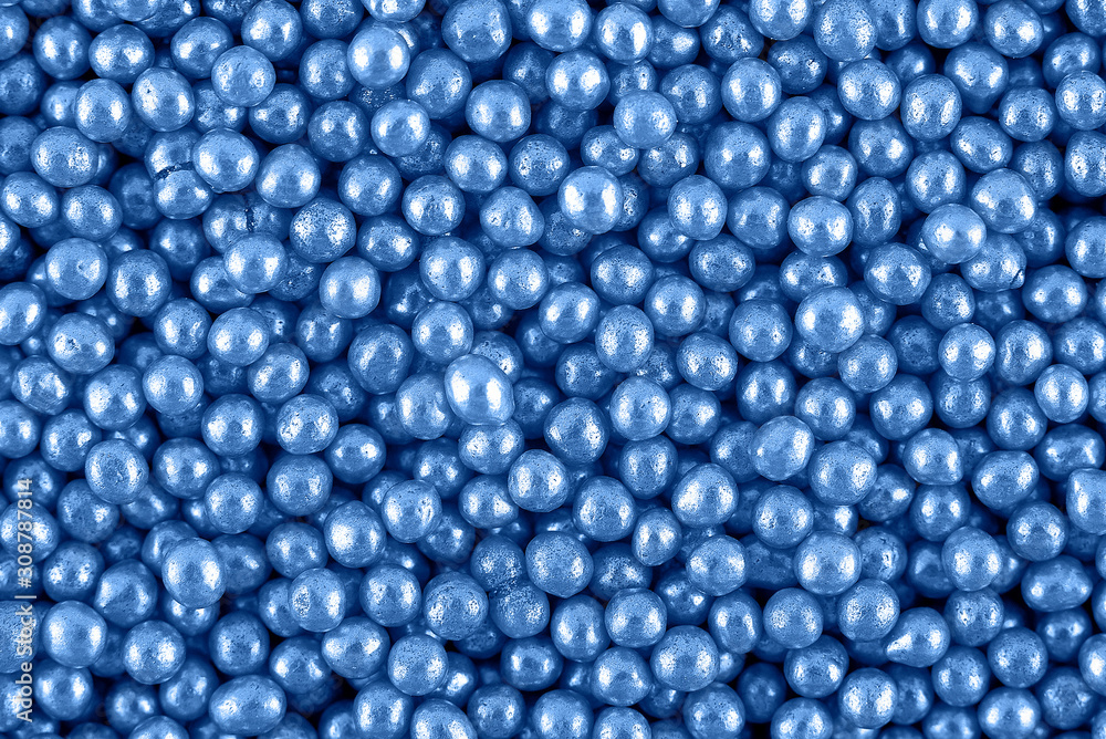 Candy sugar pearls, cake decoration, copy space. Small silver sparkle balls texture. Classic blue background. Color of the year 2020. Top view, flat lay Candy sugar pearls, cake decoration, copy space. Small silver sparkle balls texture. Classic blue background. Color of the year 2020. Top view, flat lay