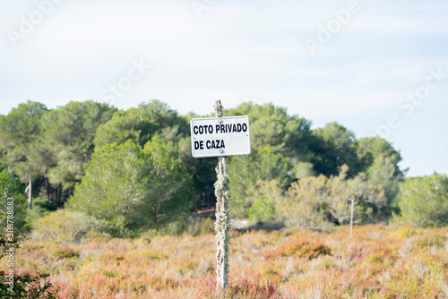 Coto privado de caza - Signboard with spanish words for private hunting ground. Natural park Es Trenc, Majorca. Landscape with several vegetation. photo