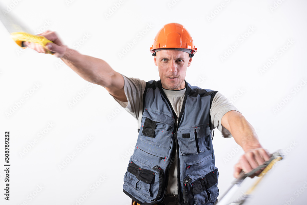 A builder with hacksaws in a helmet mocks. On a light background. A builder with hacksaws in a helmet mocks. On a light background.