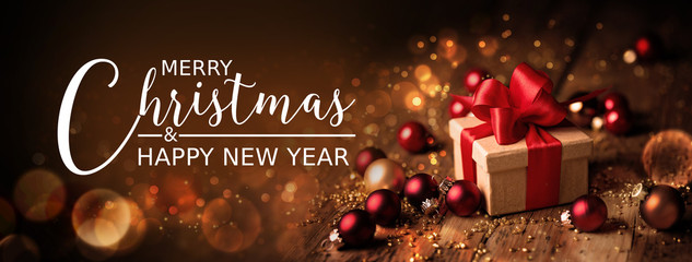 Christmas Card  -  Merry Christmas and happy new year  -  Gift box and ornaments on rustic wooden background with magic lights  -  Banner, header