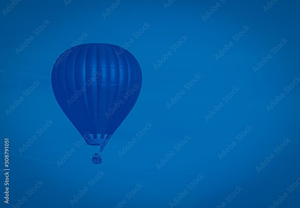 Obraz premium Classical blue colored hot-air balloon flying in the sky, toned