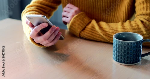 Woman Concerned About Excessive Use Of Social Media Laying Mobile Phone Down On Table