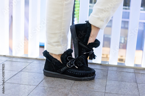 black womens ugg made of nubuck with rich trim and knitted details with fur on the leg of the model