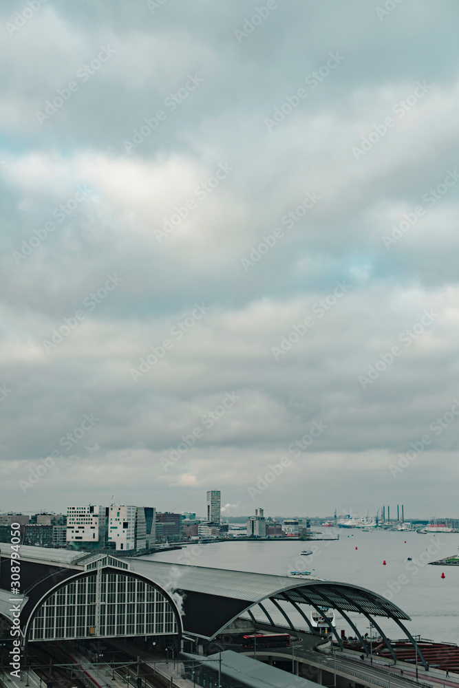 Fototapeta premium Central train station of the city of Amsterdam under cloudy sky in autumn. High angle view.