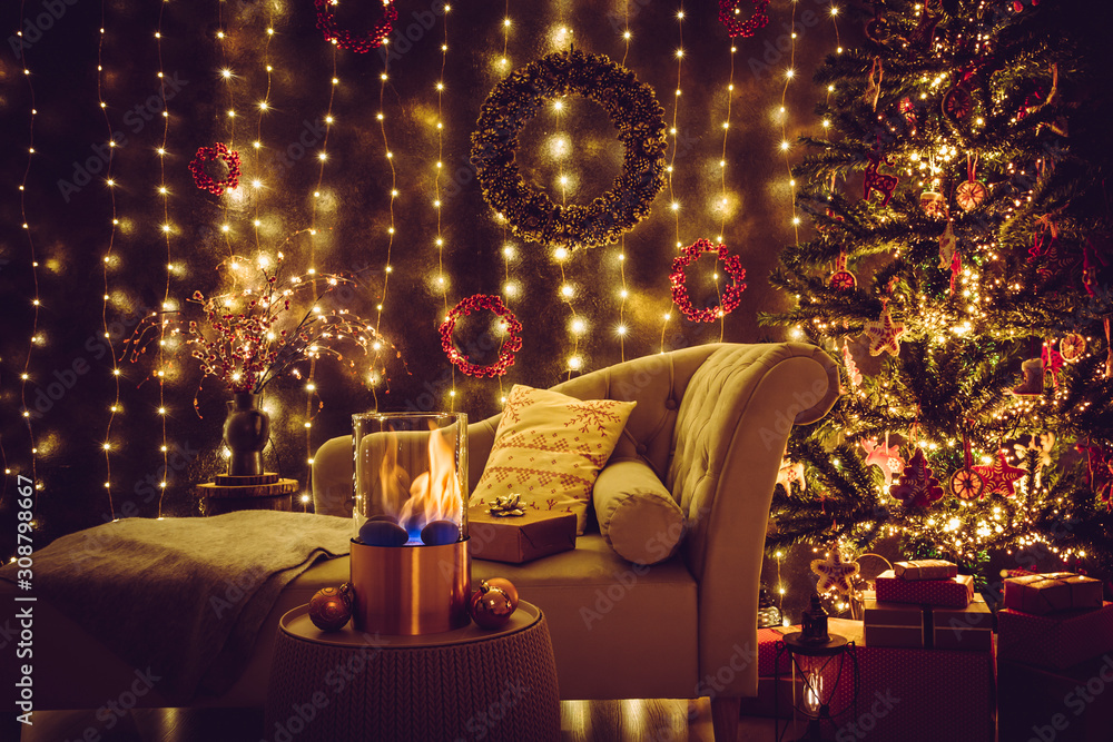 Selective focus on modern freestanding portable glass and copper metal  fireplace burning bio ethanol gas on living room table with cozy Christmas  eve home decor interior on background. foto de Stock