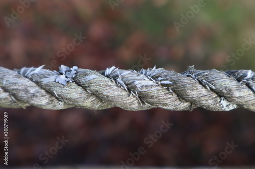 Closeup of a section of old, worn and frayed rope