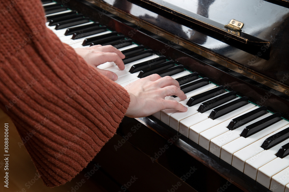 Fototapeta premium Girl playing the piano. Close up . Hands on the keys.