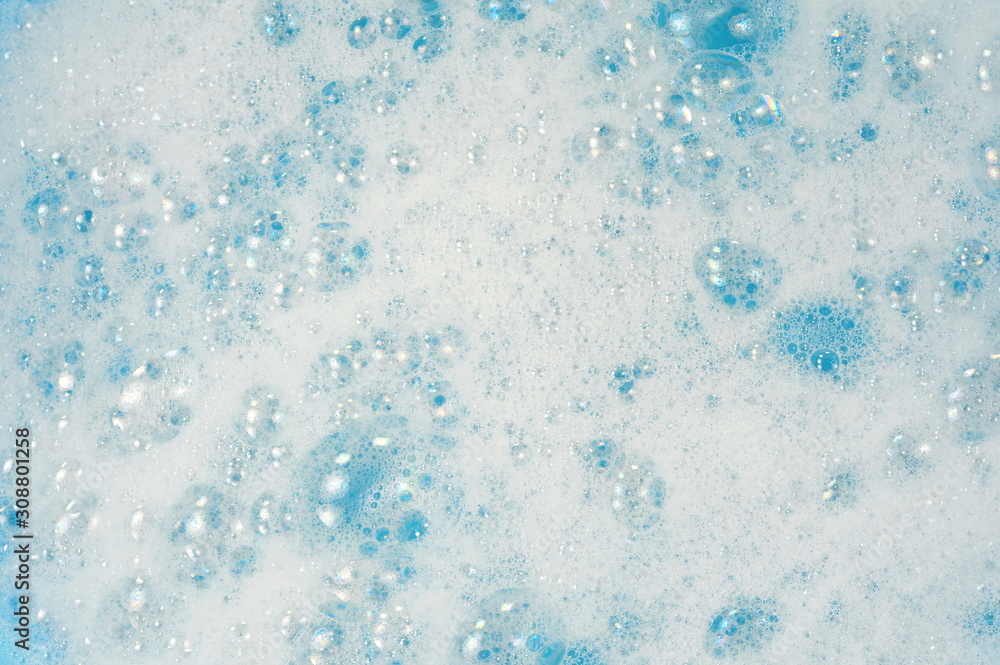 Foam bubble from soap or shampoo washing on blue background, top view. Foam background. White foam.