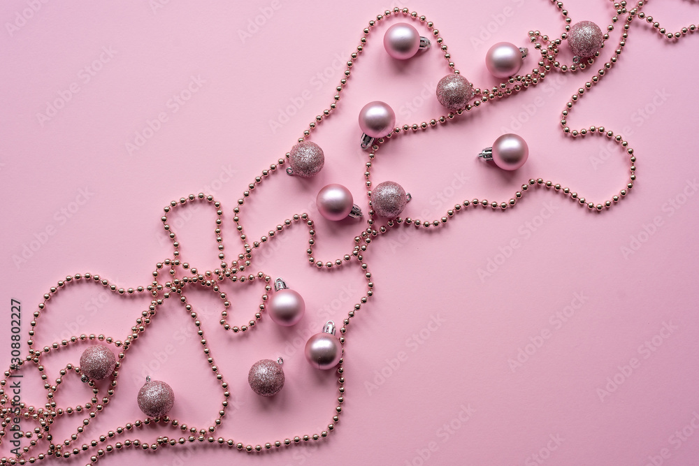 Christmas balls and garland on a pink background, New Year concept. Top view, flat lay. Christmas balls and garland on a pink background, New Year concept. Top view, flat lay.